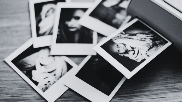 Schwarz-weiß-Fotografie unsortierter Kinderfotos – Symbolbild für verdrängte Kindheitserinnerungen und Kindheitstrauma