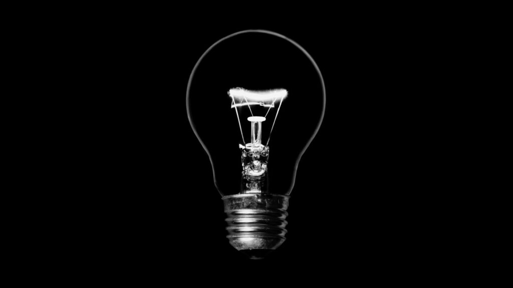Schwarz-weiß-Fotografie einer leuchtenden Glühbirne vor schwarzem Hintergrund – Symbol für Klarheit, Erkenntnis und die Wiederentdeckung der eigenen Wahrheit nach Gaslighting