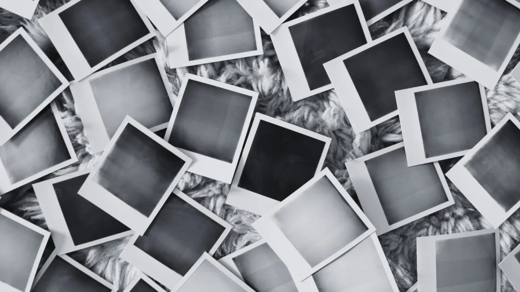 Viele leere Polaroidfotos auf weicher Unterlage – Symbol für verdrängte oder fehlende Kindheitserinnerungen bei traumatischer Kindheit