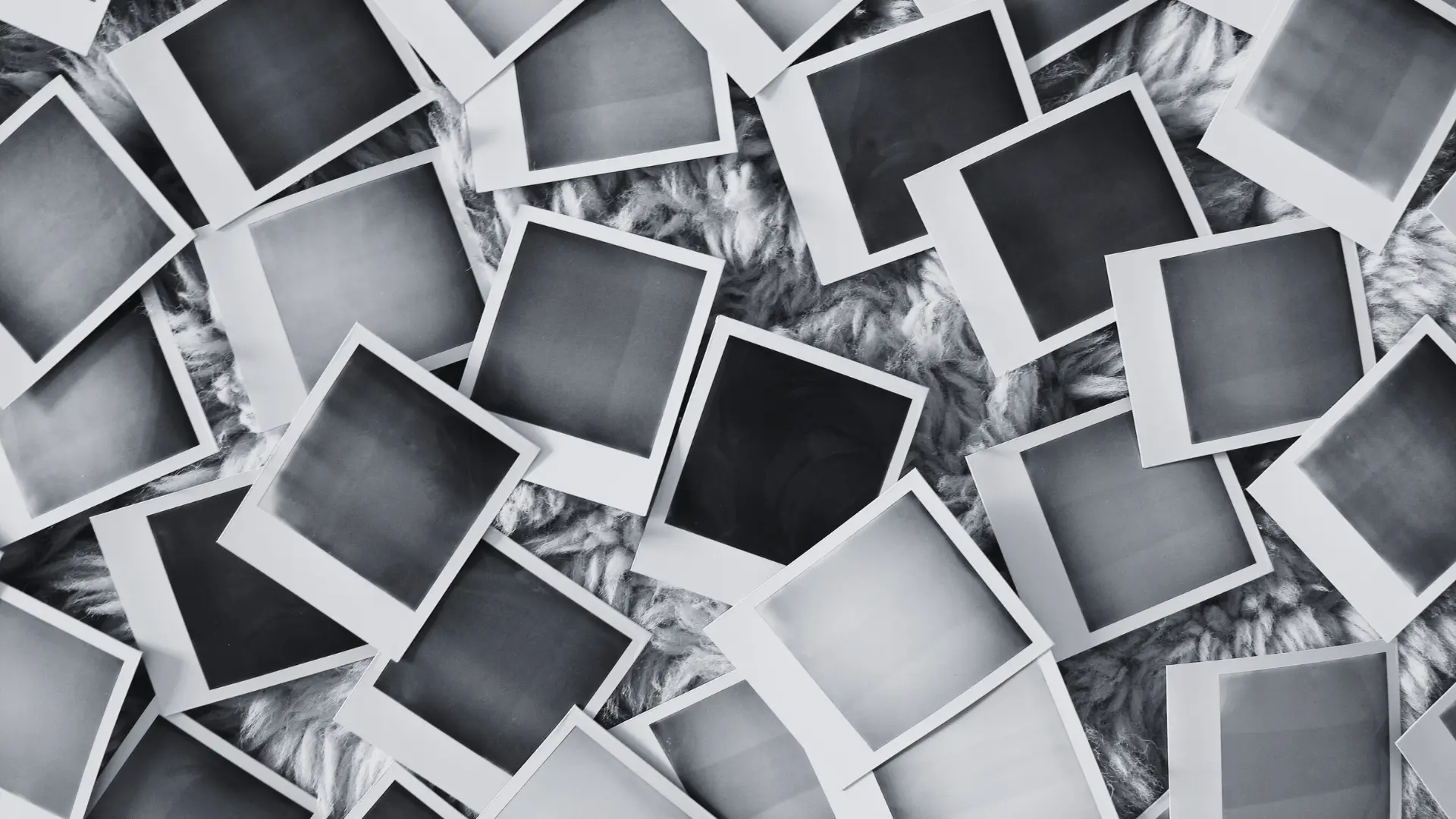 Viele leere Polaroidfotos auf weicher Unterlage – Symbol für verdrängte oder fehlende Kindheitserinnerungen bei traumatischer Kindheit