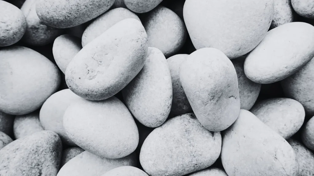 Nahaufnahme von hellen, glatten Steinen – Symbolbild für Erstarrung, inneren Druck und die Schutzmechanismen des Nervensystems bei Trauma.